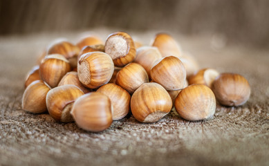 Heap of fresh ripe hazelnuts on an old tree stump. Shallow depth of field.