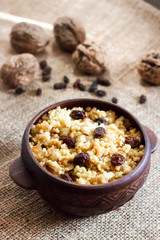 Wall Mural - Sweet millet porridge with dark raisins in ceramic rustic bowl