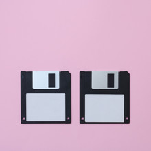 Two Floppy Disks On A Pink Background.