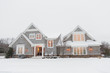 © Shannon - Wood shingled home in snow with warm lights illuminating windows