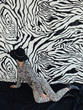 © Sergey Filimonov/Stocksy - Anonymous stylish female looking at zebra wall