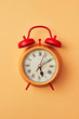 © Yaroslav Danylchenko/Stocksy - Retro style yellow alarm clock with red bells on an yellow backg