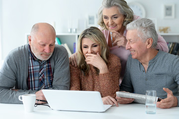 Poster - Close up portrait of two senior couples sitting at table