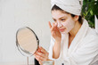© lordn - Young woman applying face mask at home. Natural Skin Care Routine. Cleaning face with natural cosmetics.