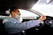 © Santi Nunez/Stocksy - Senior businessman driving a car