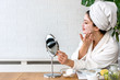 © lordn - Young woman applying face mask at home. Natural Skin Care Routine. Cleaning face with natural cosmetics.