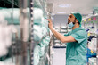 © Santi Nunez/Stocksy - Male doctor in uniform and mask searching medical equipments on shelves