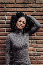 Beautiful Afro Woman In Front Of A Brick Wall