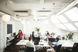 © Maskot - High angle view of male and female professionals working at desk in creative office