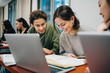© Maskot - Smiling teenage students studying at desk in school