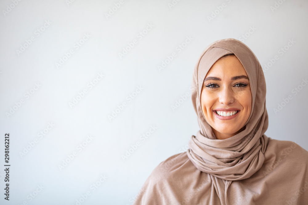 Modern, Stylish and Happy Muslim Woman Wearing a Headscarf. Arab saudi emirates woman covered with beige scarf. "Welcome" Face. One women smile with white background - obrazy, fototapety, plakaty 