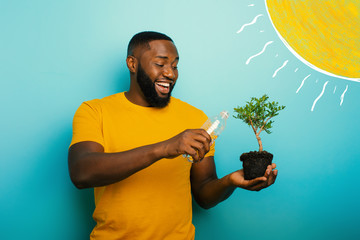 Wall Mural - Happy boy watering a small tree ready to be planted. Concept of forestation