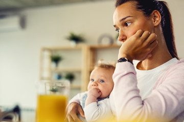young mother feeling worried and thinking of something at home.
