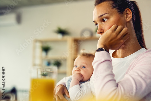 Young mother feeling worried and thinking of something at home.