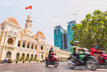 Ho Chi Minh City, Vietnam: Saigon City Hall, Vincom Center Towers And Colorful Street Traffic Blurred In Motion. Saigon Downtown With Its Famous Landmarks. Stock Image With Removed Logos.