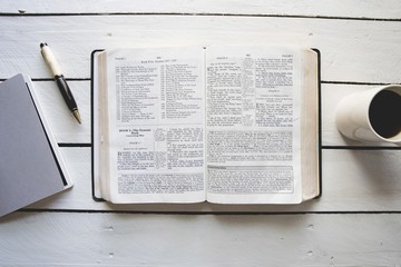 Wall Mural - Overhead shot of an open bible in between a coffee and a notepad with a pen