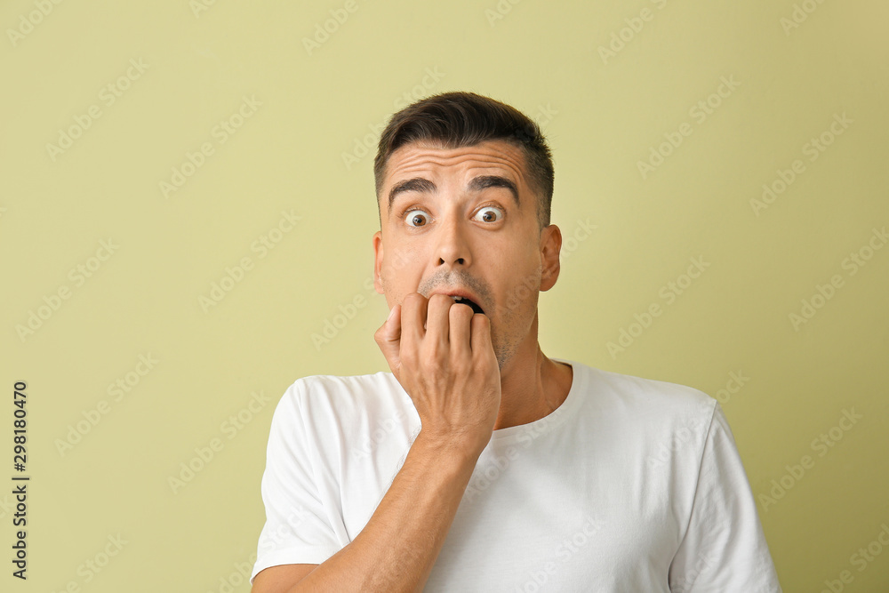 Shocked young man on color background