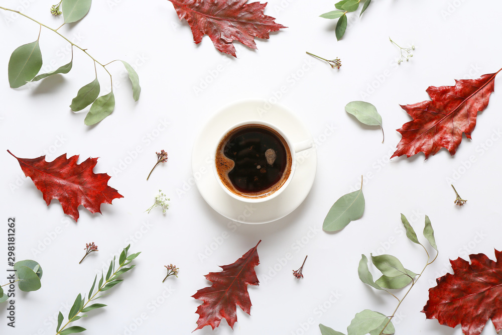 Composition with autumn flowers and cup of coffee on white background