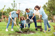 © Viktoriia - Volunteering. Young people volunteers outdoors planting trees together pouring water on ground smiling joyful cooperation