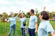 © Viktoriia - Volunteering. Young people volunteers outdoors planting trees holding tools hands up mussion complete cheerful