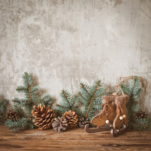 Christmas Tree Branches With Cones On A Dark Wooden Board Against A Gray Concrete Wall.