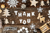 Fototapeta Na ścianę - White Letters Building The Word Thank You. Wooden Christmas Decoration Like Sled, Tree, Snowflakes And Star. Brown Wooden Background