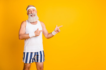 Canvas Print - Photo of aged model white hair guy directing fingers empty space advising choose healthy sports supplements wear tank-top shorts sweatband isolated yellow color background