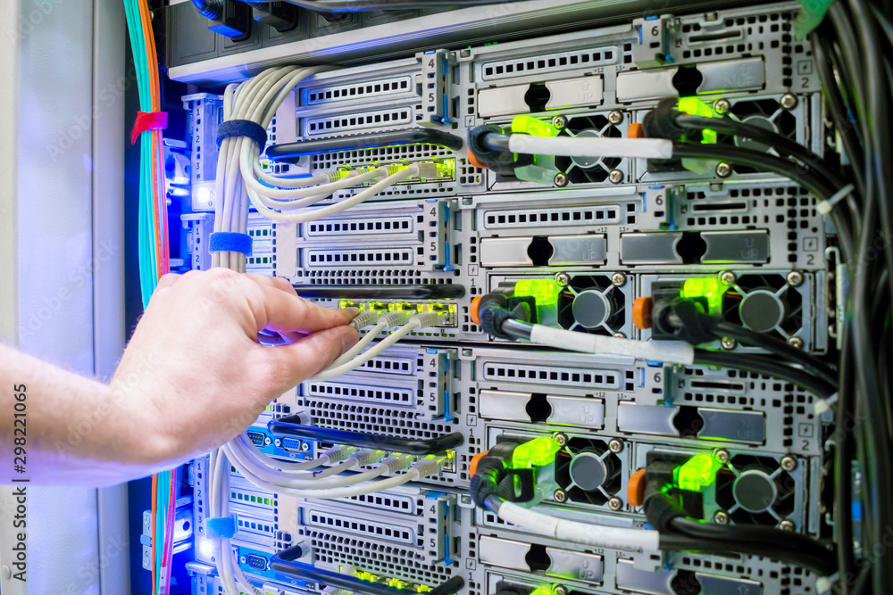The hand of a technician with a communication Internet wire is a close ...
