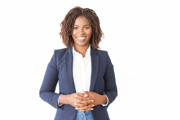 Happy cheerful female consultant looking at camera. Young African American business woman with clasped hands standing isolated over white background, smiling. Happy entrepreneur concept