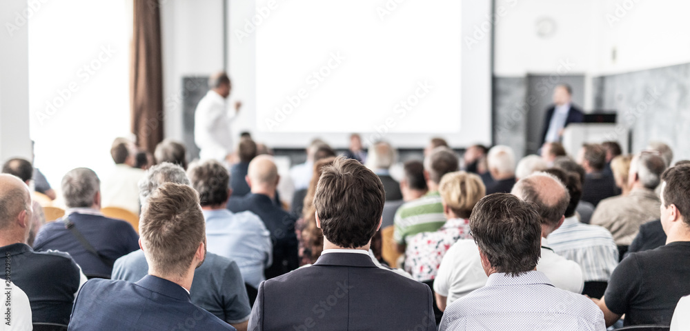 I have a question. Group of business people sitting at the chairs in conference hall. Businessman standing up asking a question. Conference and Presentation. Business and Entrepreneurship. - obrazy, fototapety, plakaty 