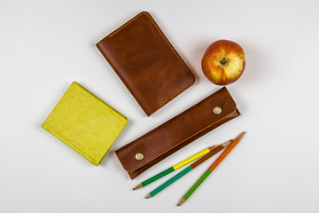 Wall Mural - case for colored pencils and a notebook with an apple on a white background, top view