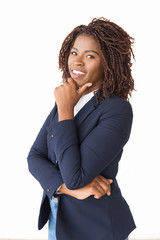 Happy joyful professional touching chin, smiling. Young African American business woman standing isolated over white background, looking at camera. Positive business portrait concept