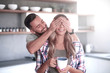 © ASDF - happy man joking with his girlfriend in the kitchen in the morning