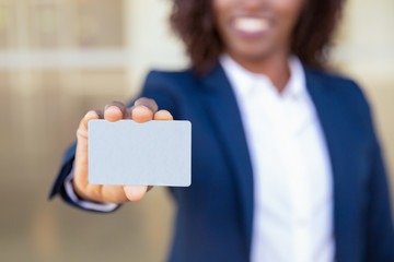 Businesswoman showing credit card. Young African American business woman holding blank card, smiling. Advertising concept