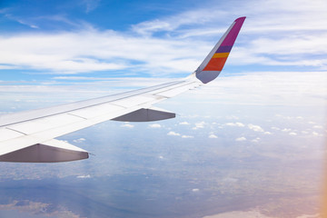 Aircraft Wing on blue sky and white clouds background.