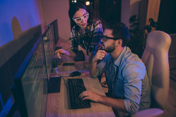 Wall Mural - Profile photo of it specialist two business people night coworking together geek guy listen task manager lady watch monitor errors bugs writing security code office indoors