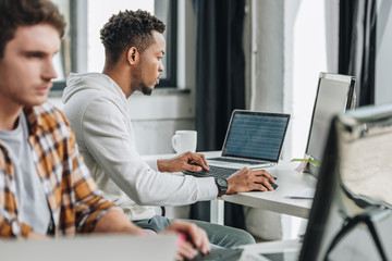 selective focus of two multicultural programmers working together in office