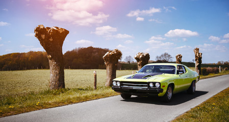 young attractive man in his oldschool us muscle car