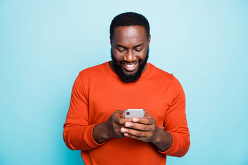 Wall Mural - Photo of cheerful positive handsome man holding telephone smiling toothily searching information new isolated vivid blue color background