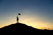 © cofficevit - Silhouette of people and flag on top mountain, sky and sun light background. Business success and goal concept.