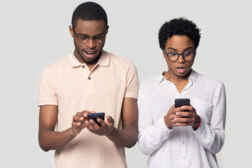 Wall Mural - Head shot shocked African American couple using phones, reading news