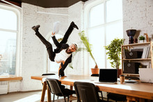 Young Caucasian Businessman Having Fun Dancing Break Dance In The Modern Office At Work Time With Gadgets. Management, Freedom, Professional Occupation, Alternative Way Of Working. Loves His Job.