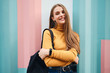 Beautiful smiling casual student girl joyfully looking in camera over colorful background