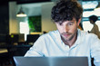 © PhotoAlto - Serious young businessman using laptop in office