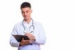 © Ranta Images - Young handsome man doctor writing on clipboard