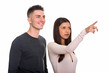 © Ranta Images - Studio shot of young couple with woman pointing finger and happy