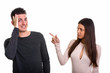 © Ranta Images - Studio shot of young couple with woman pointing finger and man l