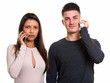 © Ranta Images - Studio shot of young couple talking on mobile phone together