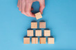 © ink drop - Hand choosing a wooden block from a set. Business choice concept