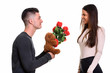 © Ranta Images - Young happy couple smiling and in love with man giving red roses